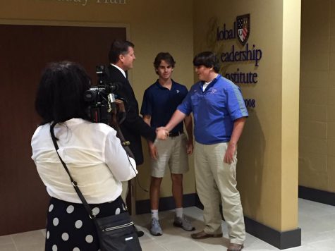 Cameras roll as GLI director Col. William Merrill congratulates juniors Tanner McCraney and Kole Crotwell on their contribution to the Red Cross. Photo courtesy of Jackson Prep.