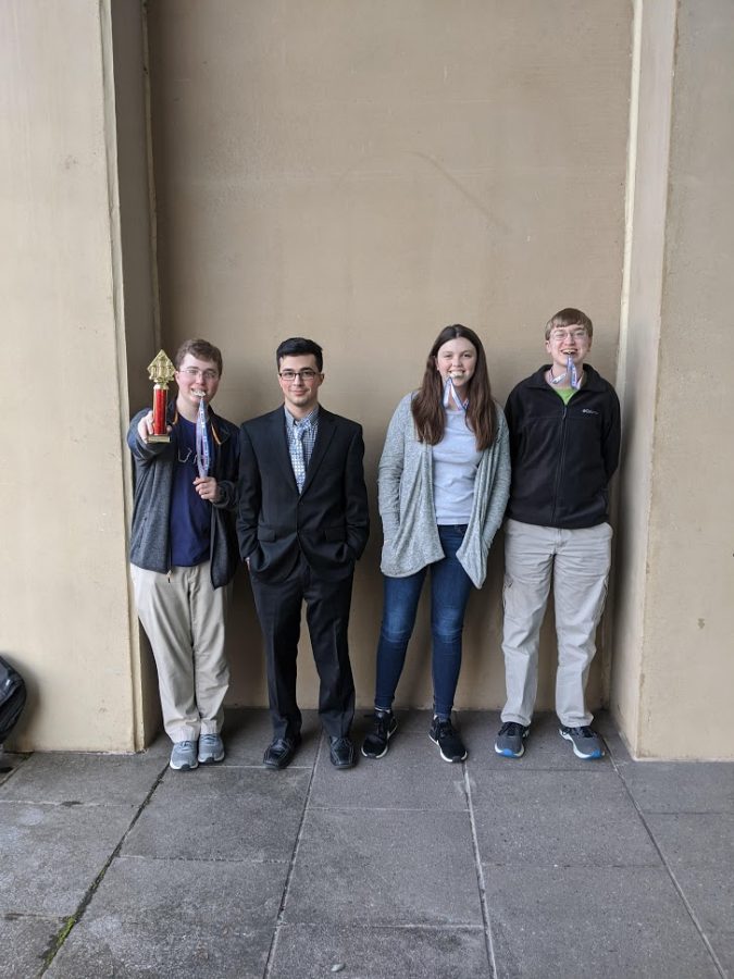 Members of the senior high A-team pose with their trophy. (from left to right) Junior Selby Ireland, junior Eli Venarske, sophomore Megan Tomlinson, and junior Joseph Watts. 