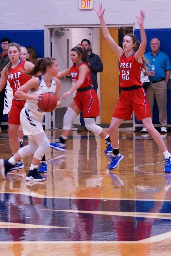 Julia Zouboukos, Mackenzie Shoemaker, and Caroline Dreher play defense. 