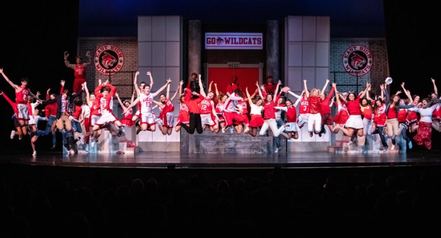 The Prep cast of High School Musical leaps into the air. 